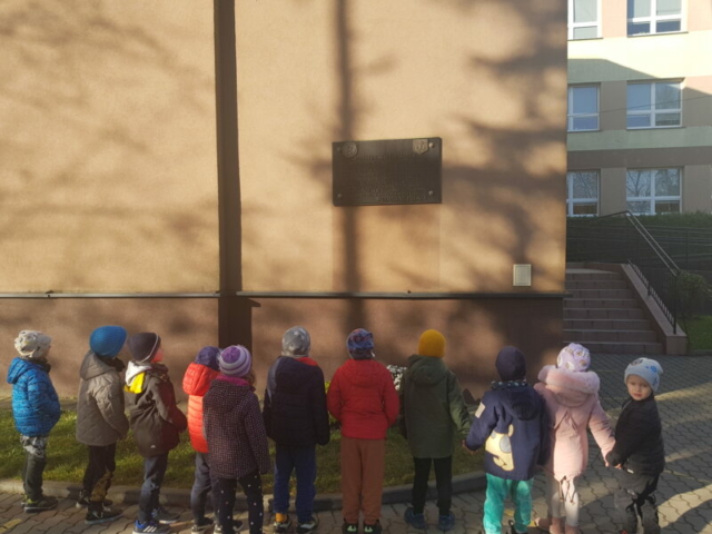 Dzieci z grupy 7 patrzą na tablicę pamiątkową