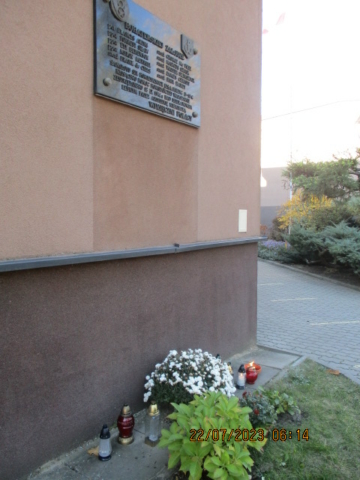 Zdjęcie przedstawia tablicę upamiętniającą załogę samolotu B17 na terenie Szkoły Podstawowej w Dziekanowie Leśnym.